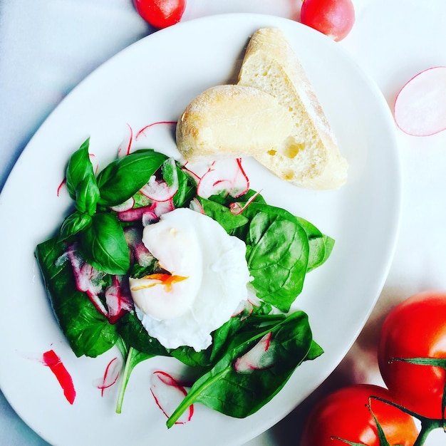 High angle view of salad served with bread in plate on table