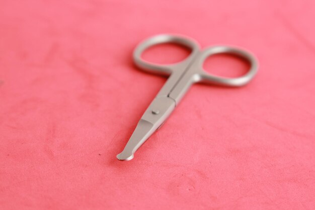 High angle view of scissors over pink background