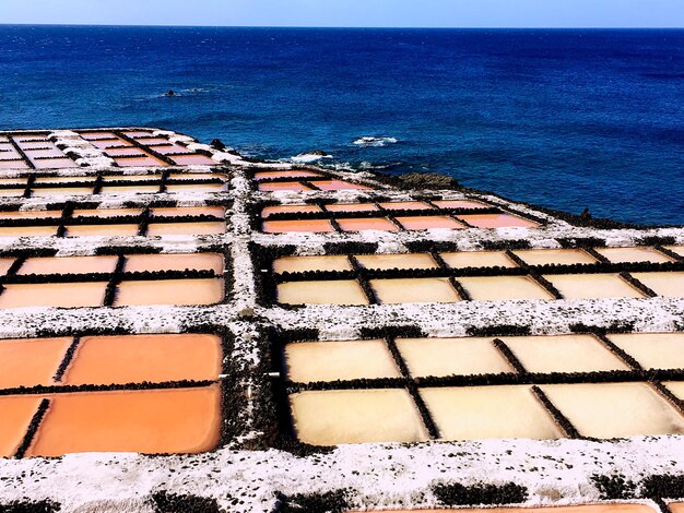 High angle view of sea shore against blue sky