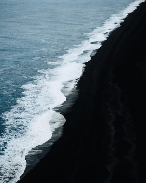 黒い砂浜の海の波の高角度の景色