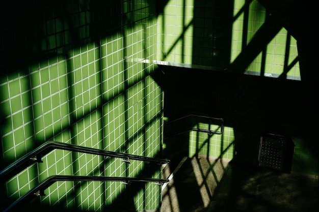 High angle view of shadow on green tile wall