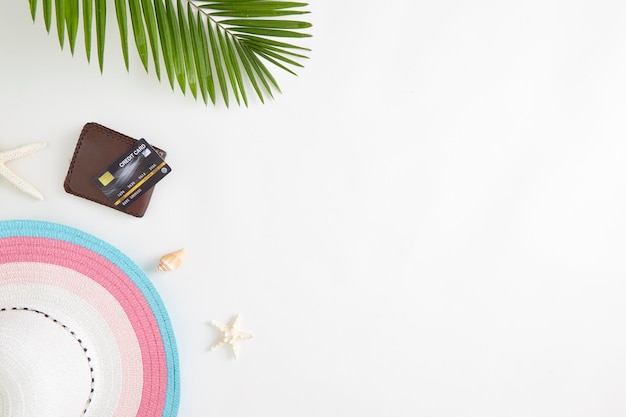 High angle view of shells with card and sun hat on white background