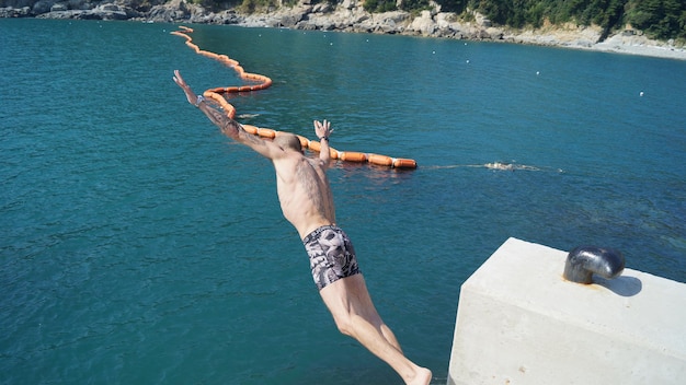 High angle view of shirtless man jumping in sea