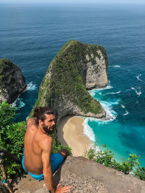 High angle view of shirtless man on rock at beach