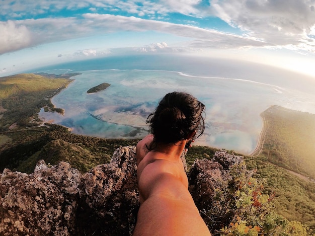 Foto vista ad alta angolazione di un uomo senza camicia in piedi su una scogliera