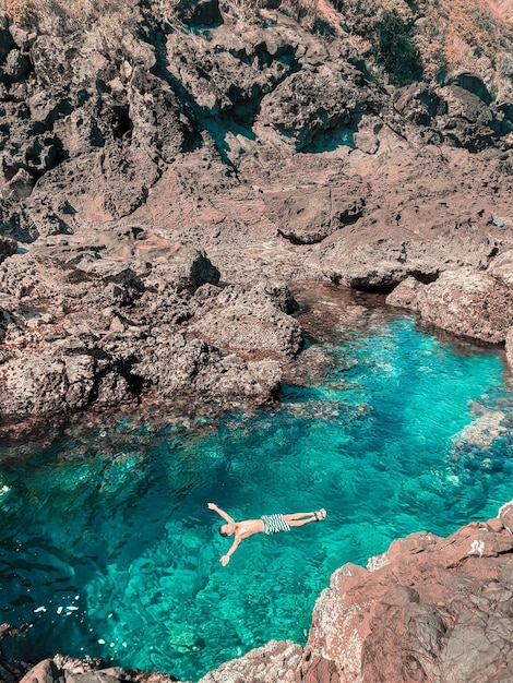 海で泳いでいるシャツを着ていない男の高角度の景色