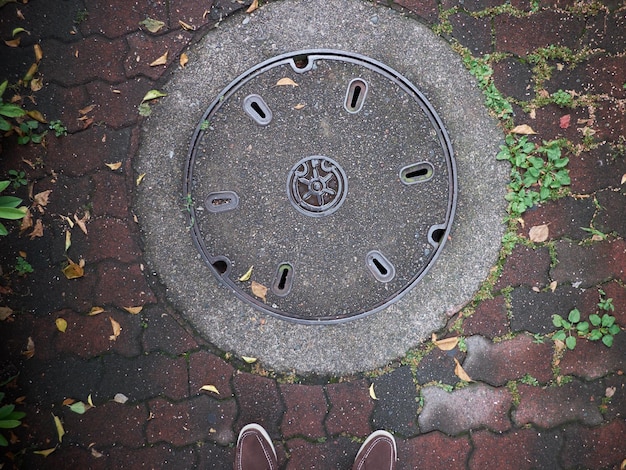 Photo high angle view of shoes by manhole