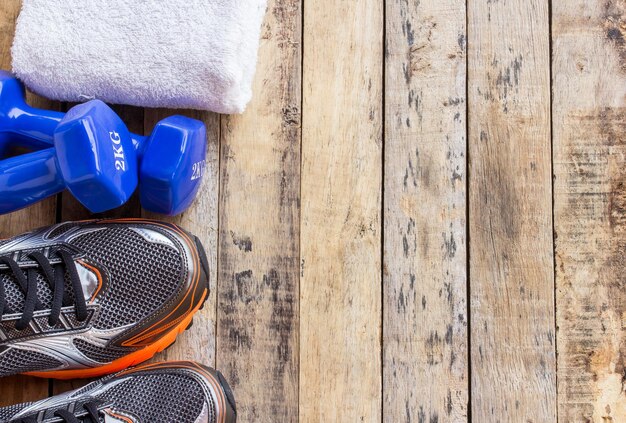 High angle view of shoes and dumbbell on wooden table