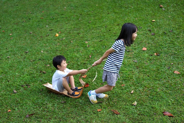 Photo high angle view of siblings playing on grassy field at park