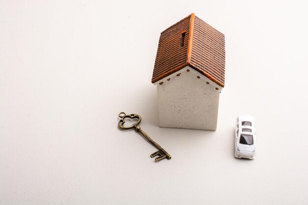 High angle view of a small house with a key and a car on the table - concept of property