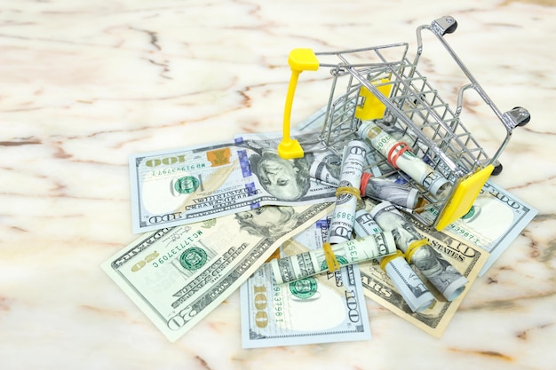 Photo high angle view of small shopping cart with paper currencies on table