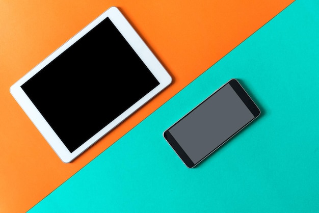 Photo high angle view of smart phone and digital tablet over colored background