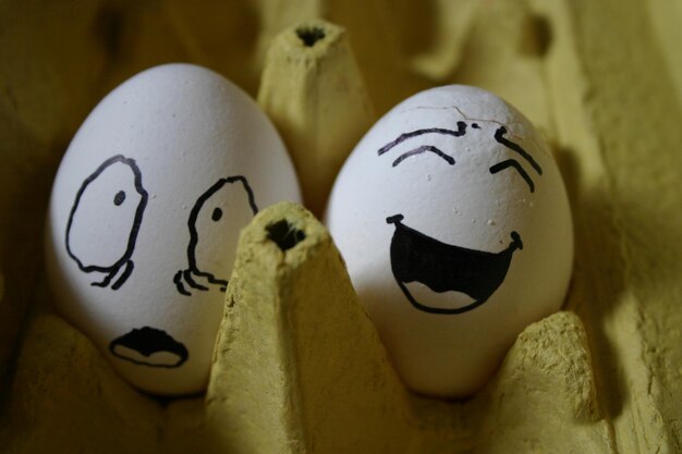 Photo high angle view of smiley face on egg in carton