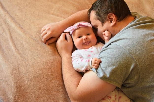 Photo high angle view of smiling baby with father on bed