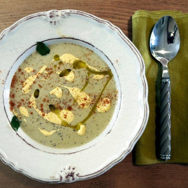 Foto vista ad alto angolo della zuppa nel piatto con il cucchiaio sul tavolo