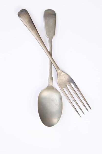 High angle view of spoon with fork over white background