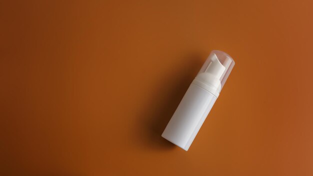 High angle view of spray can on orange background