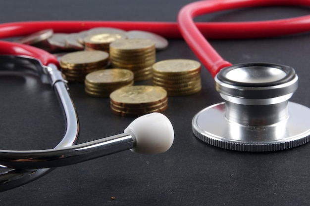 Photo high angle view of stethoscope and coins against black background