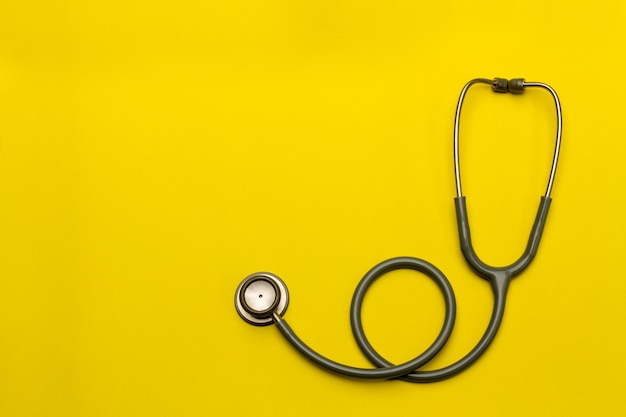 High angle view of stethoscope on yellow background