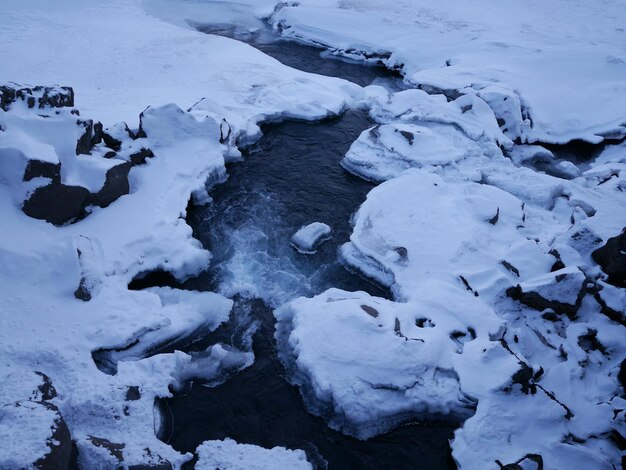 High angle view of stream amidst snow