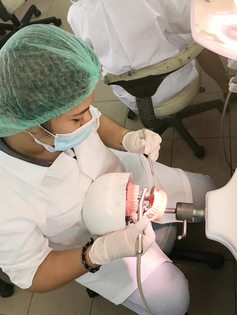 High angle view of student practicing surgery in dentist clinic