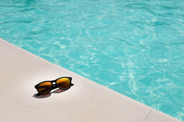 Foto vista ad alto angolo di occhiali da sole in piscina