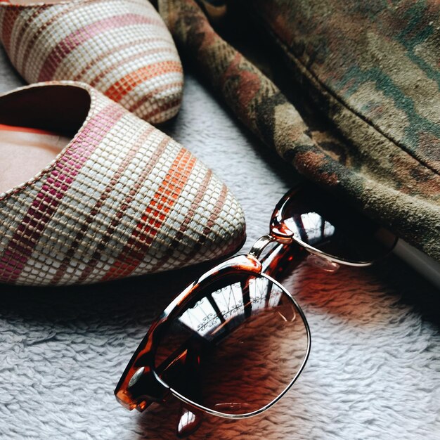 High angle view of sunglasses with shoes on table