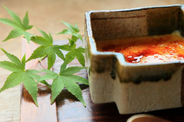 High angle view of sweet food in container by leaves on floor