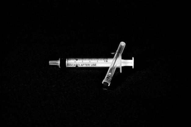 High angle view of syringe on black background