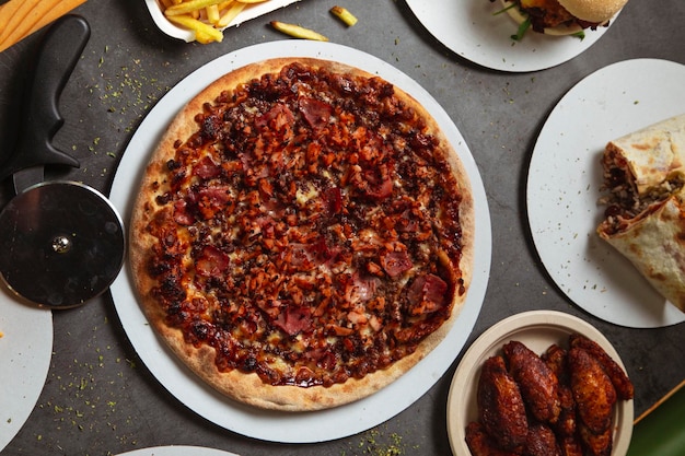 High angle view of the table with various pizzas burgers and burritos