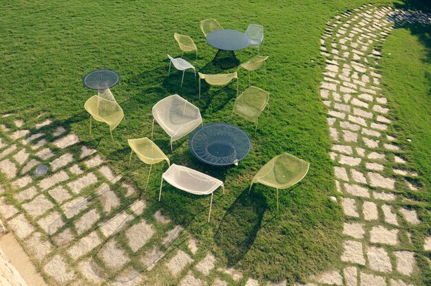 High angle view of tables and chairs in lawn during sunny day