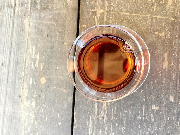 High angle view of tea in glass on wooden table