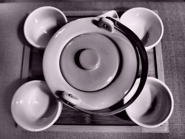 Photo high angle view of teapot with empty cups on table