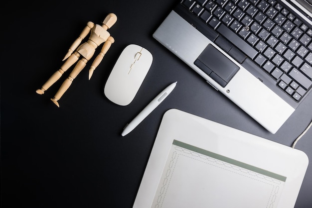 Photo high angle view of technology with figurine with pen on table