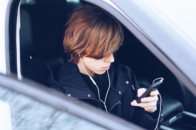 high angle view of teenage boy listening music while sitting in car
