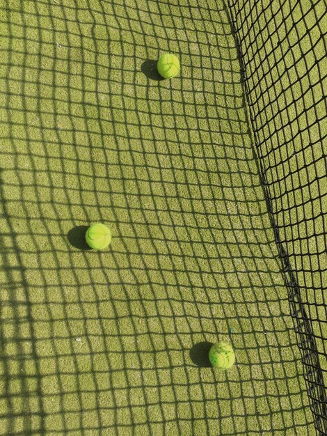 Photo high angle view of tennis balls on grassy field in court