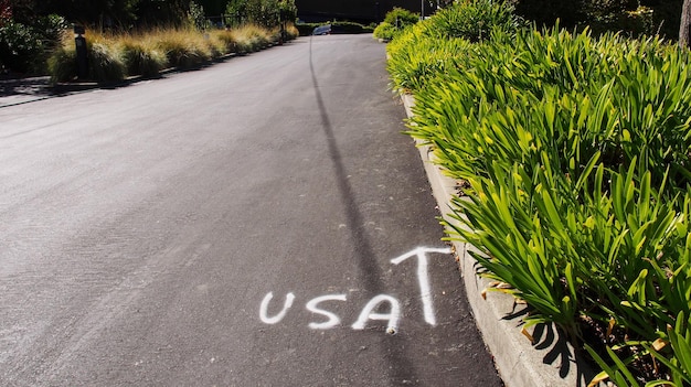 Photo high angle view of text and arrow symbol written on street