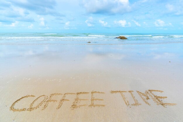 Photo high angle view of text on sand at beach against sky