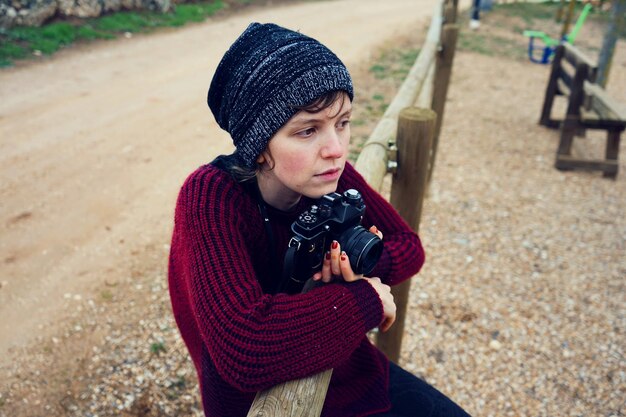 Photo high angle view of thoughtful mid adult woman sitting on railing