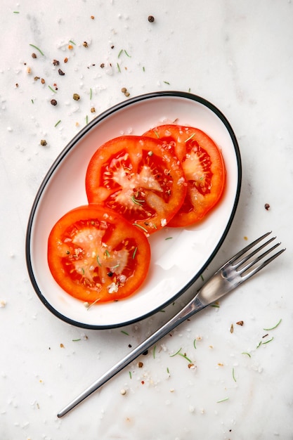 Photo high angle view of tomatoes and sugar in plate on table