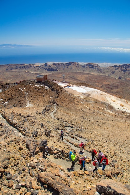 High angle view of tourist walking over hill against cloudy sky