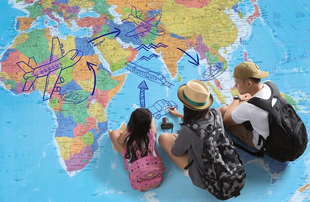 High angle view of tourists with backpacks sitting on map