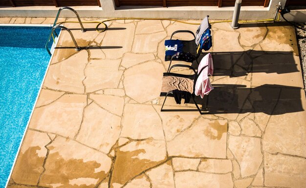 Photo high angle view of towels drying on chairs at poolside