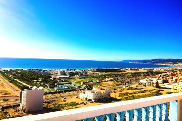 High angle view of townscape by sea against clear sky