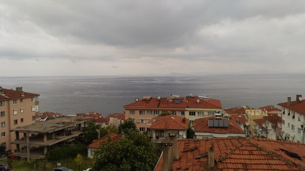 High angle view of townscape by sea against sky