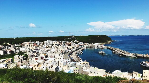 High angle view of townscape by sea against sky