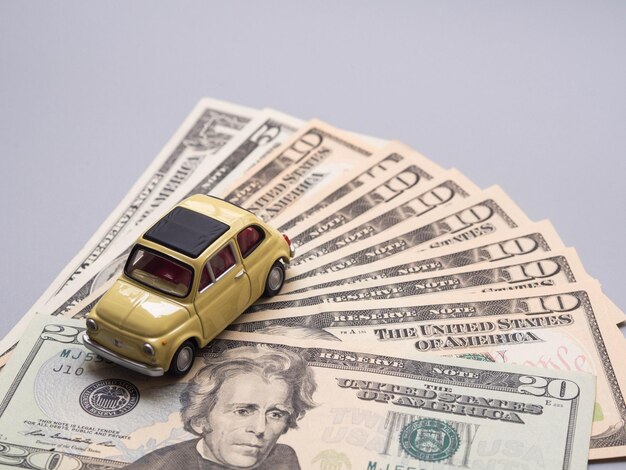 Photo high angle view of toy car with paper currency against gray background