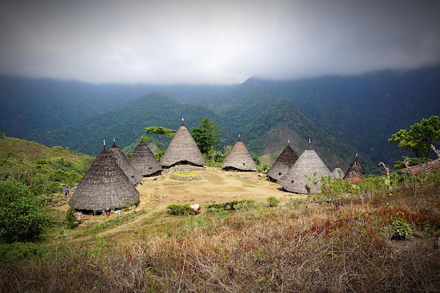 High angle view of traditional houses on hill against mountains during foggy weather