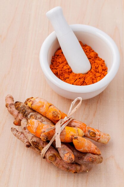 High angle view of turmeric with mortar and pestle on table