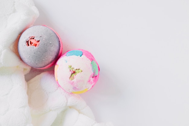 Photo high angle view of two bath bombs and napkin on white surface